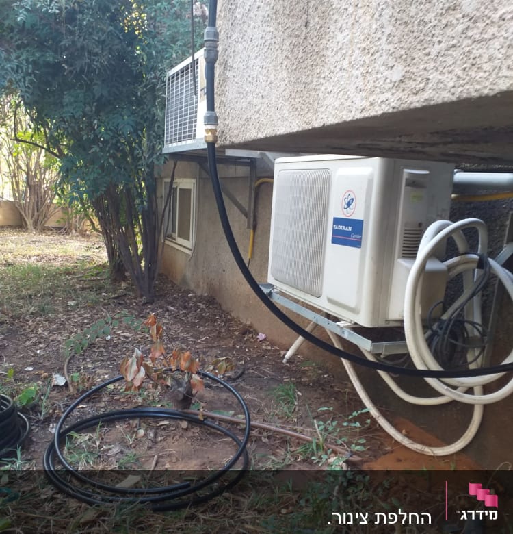 צינורות ומזגן מותקן על קיר חיצוני